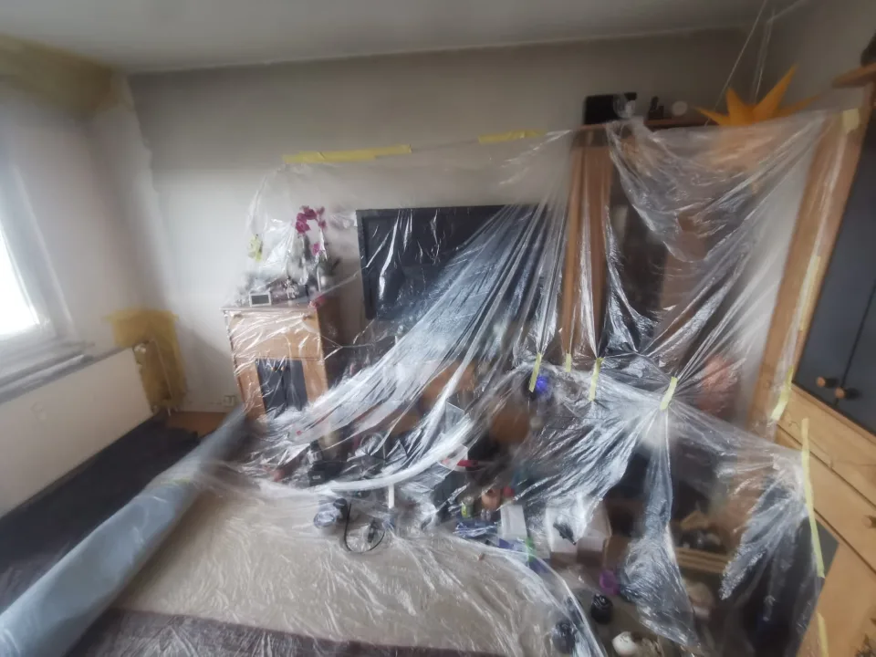 Möbel und Fernseher im Wohnbereich mit Schutzfolie abgedeckt