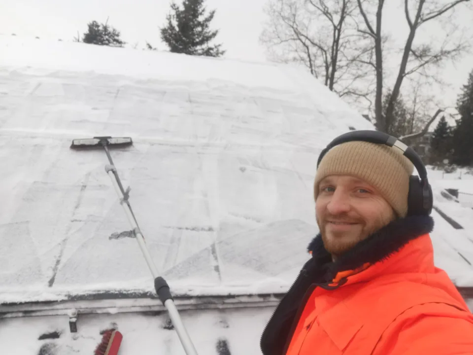 Benjamin mit Räumgerät bei einem Einsatz am schneebedeckten Dach
